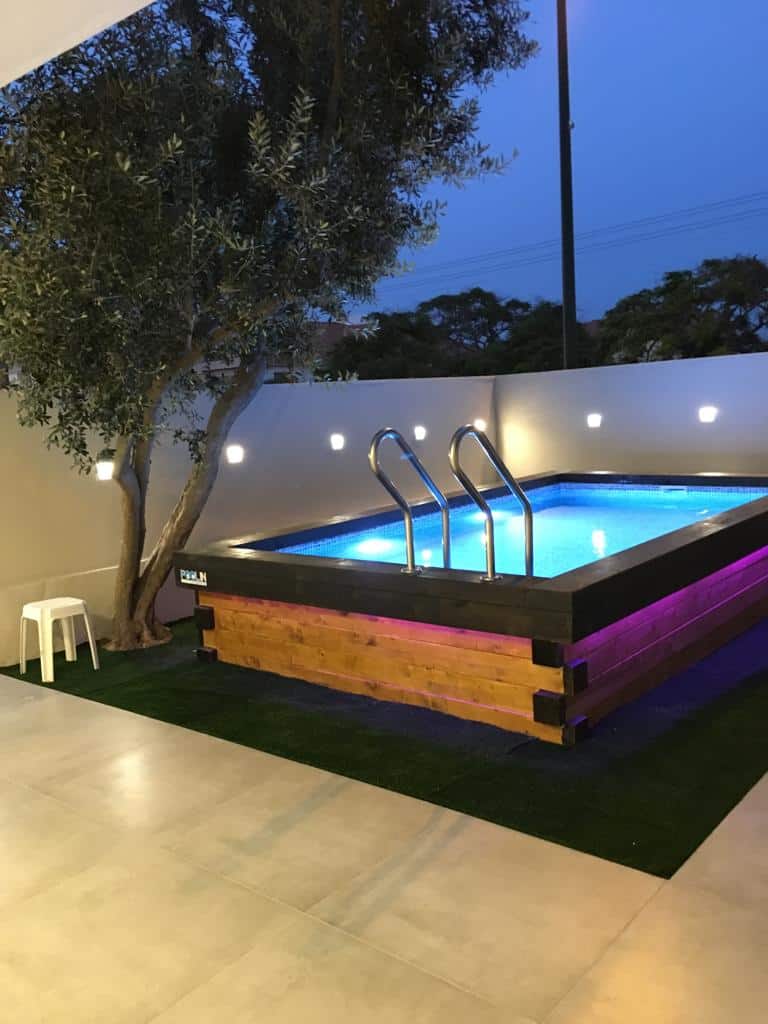 בריכת שחייה מעוצבת עם תאורה LED צבעונית בחצר פרטית.